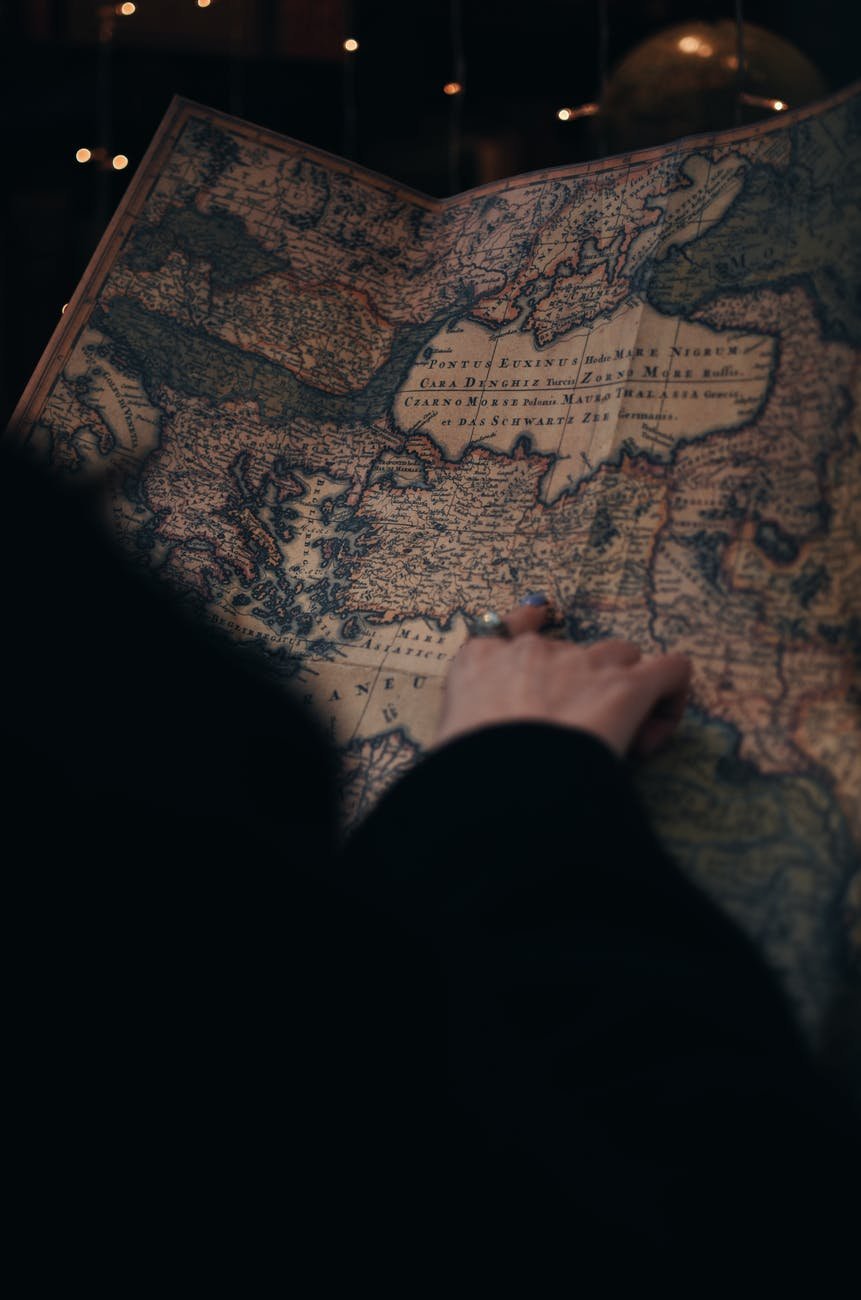 faceless woman studying vintage map in museum